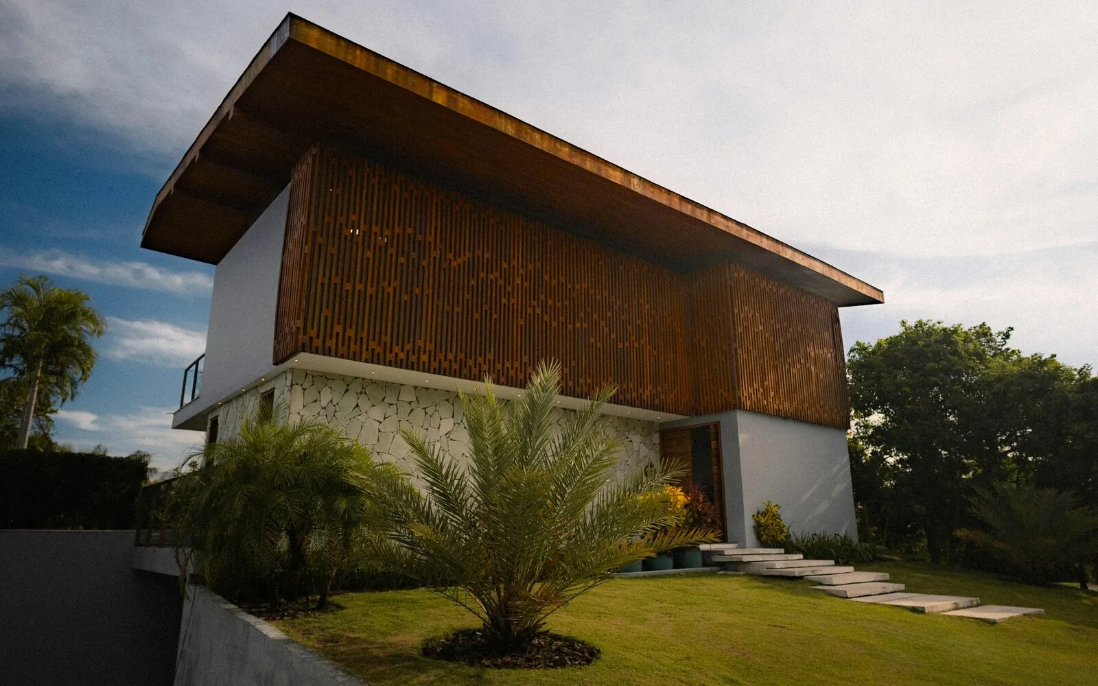 Modern residence with a stone base, timber screen facade, and a generous roof overhang
